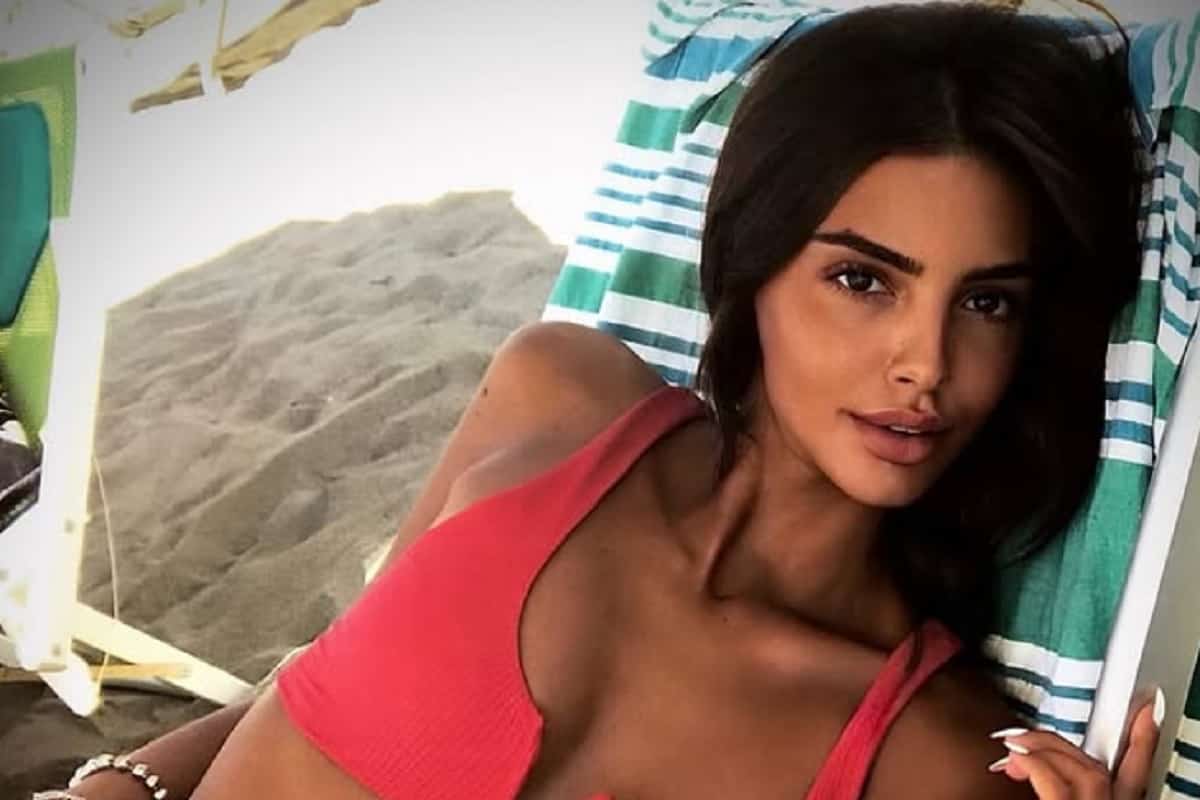 sara gaudenzi sdraiata sul lettino con bikini rosso, capelli sciolti e la spiaggia sullo sfondo