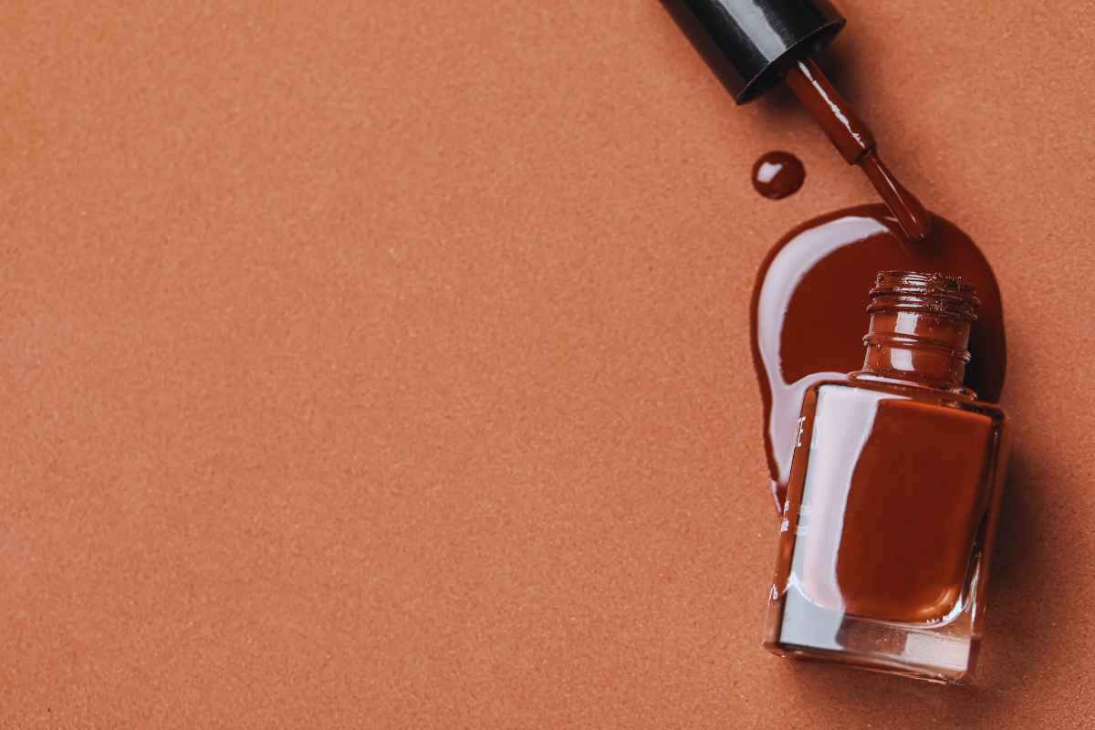 Una confezione di smalto marrone aperta con del colore che fuoriesce