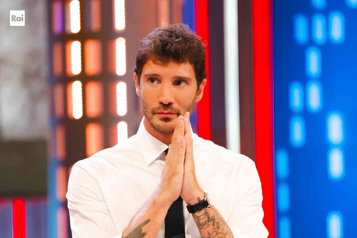 stefano de martino in camicia e cravatta con le mani giunte nello studio di affari tuoi