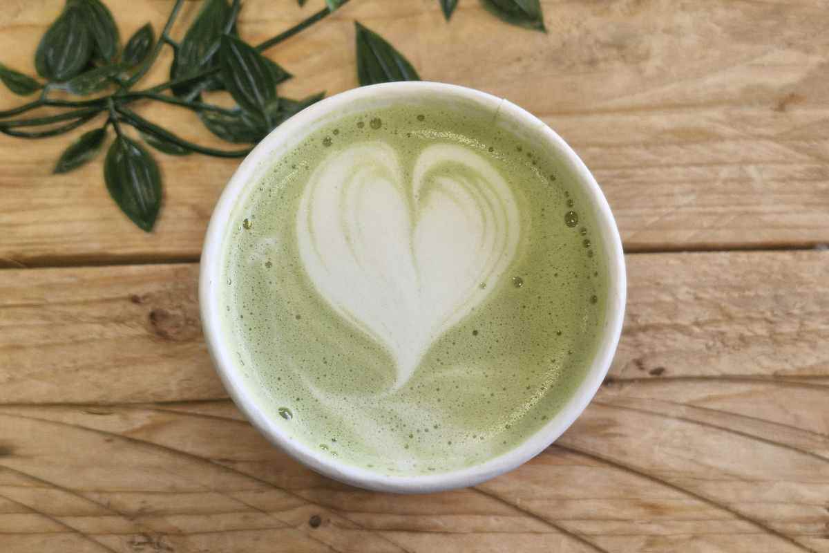 Una tazza di tè matcha con una decorazione a cuore sulla superficie