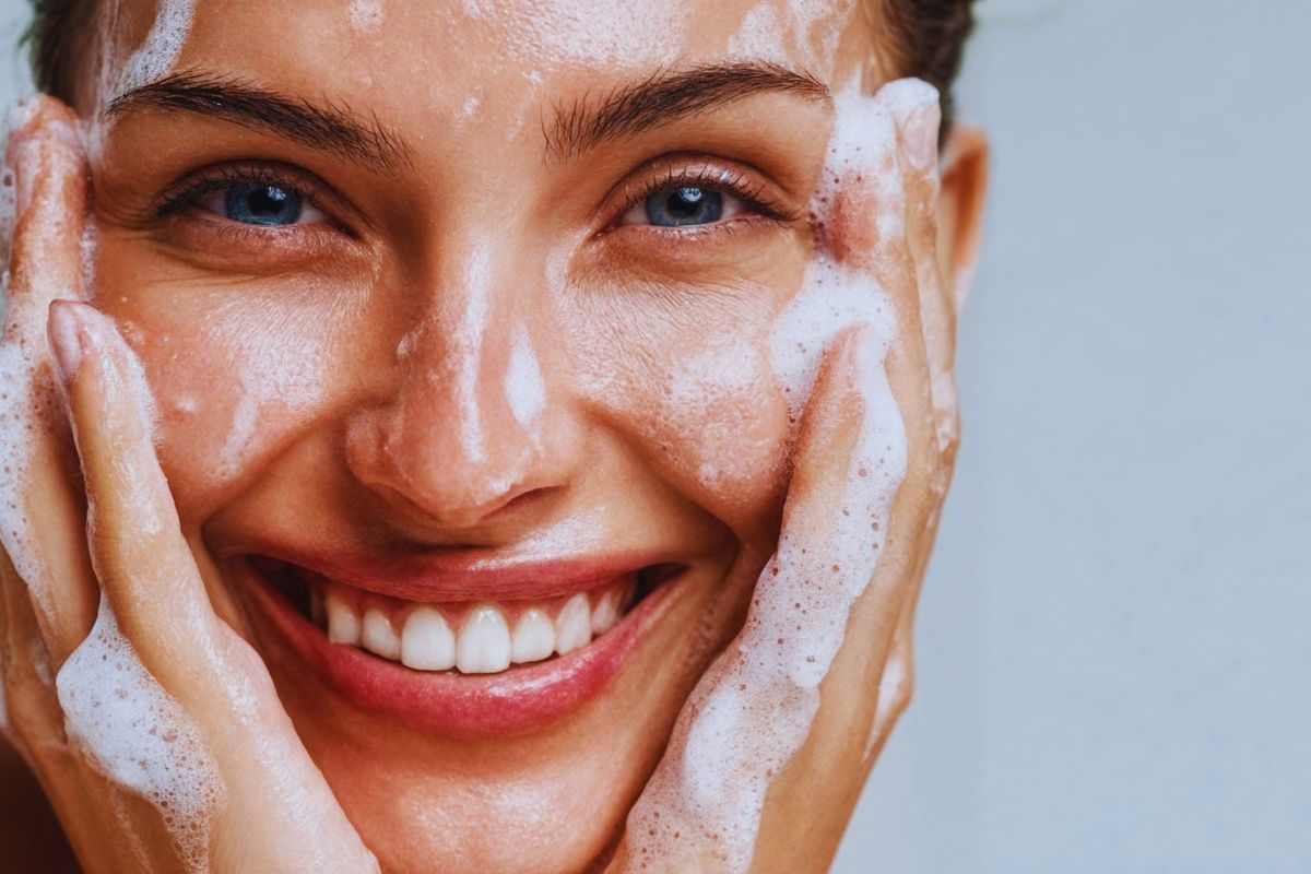 Ragazza con il volto coperto dal sapone e sorridente