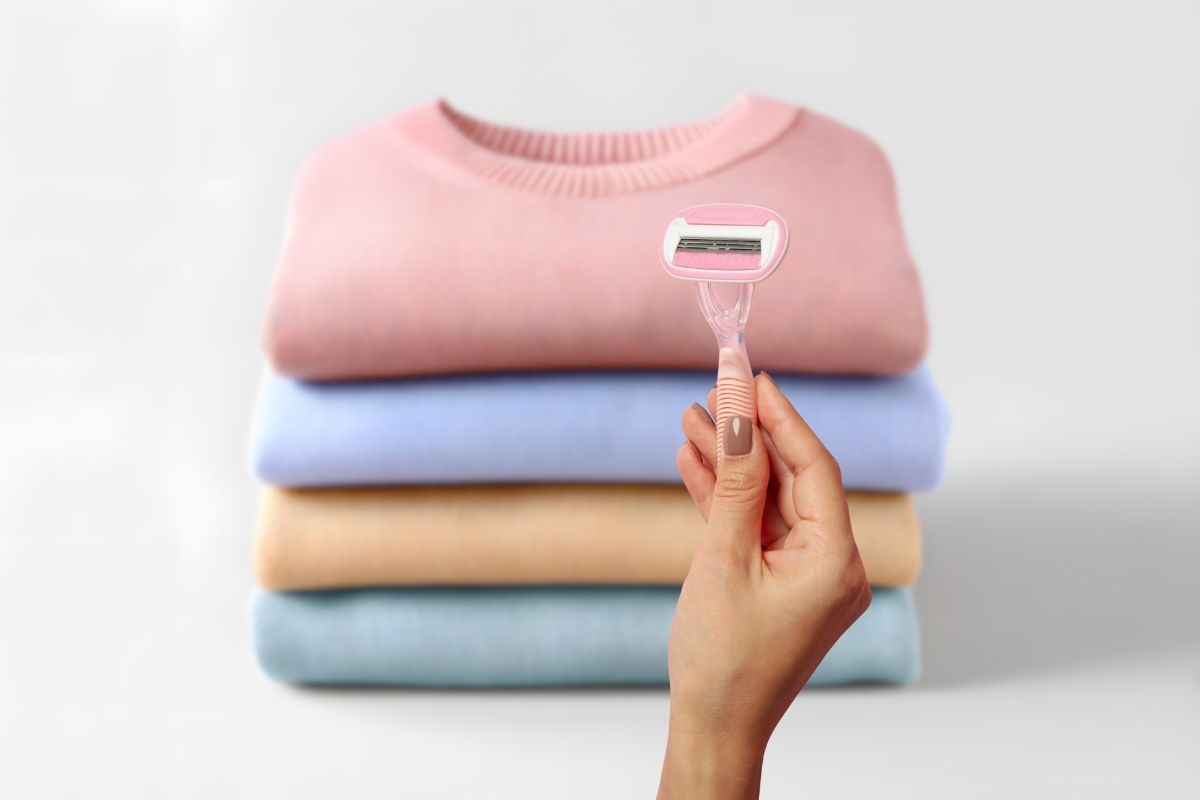 maglioni piegati e donna che mantiene una lametta