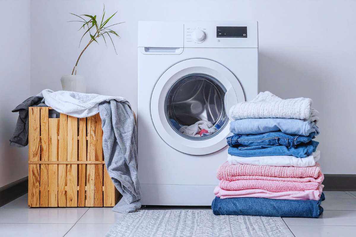 Una lavatrice con accanto dei panni piegati