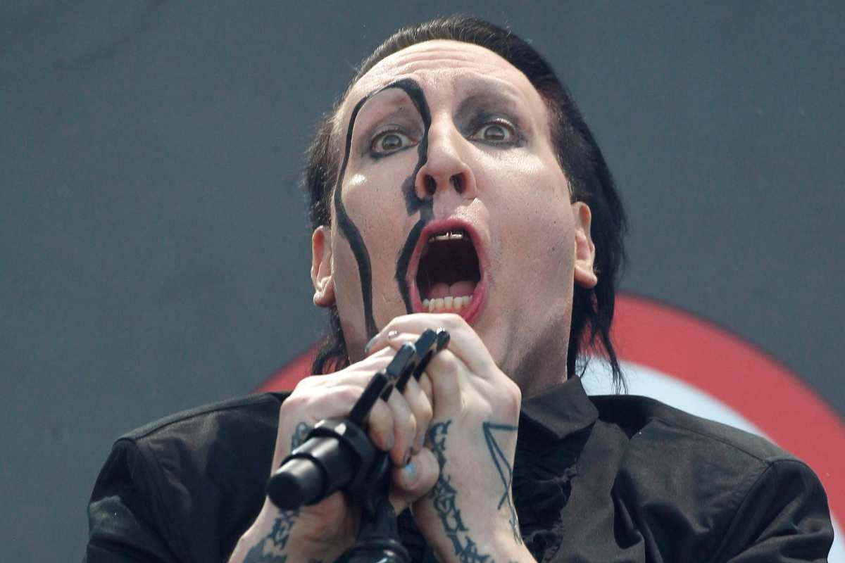 Marilyn Manson canta con il microfono davanti durante un concerto