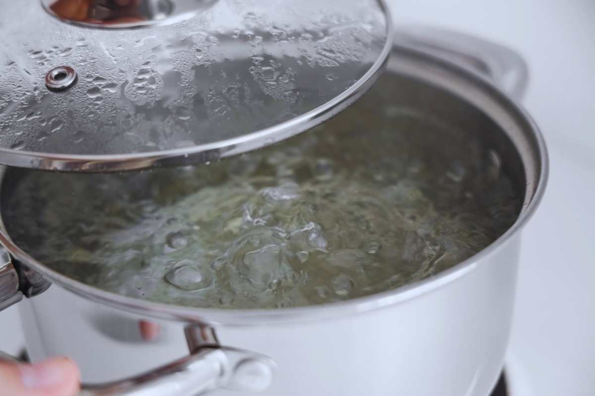 Una pentola con dell'acqua bollente e sopra un coperchio
