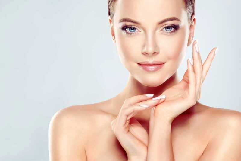 Una ragazza mezzo busto con le spalle nude e il volto luminoso e perfetto