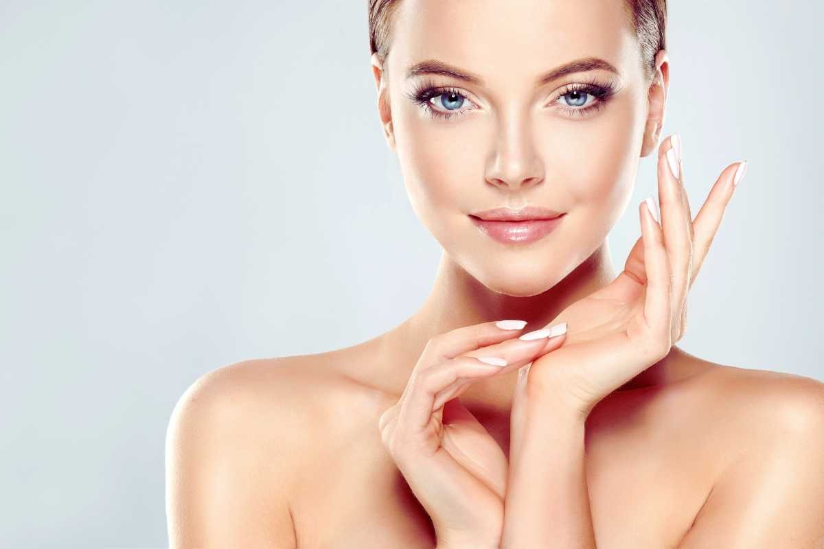 Una ragazza mezzo busto con le spalle nude e il volto luminoso e perfetto